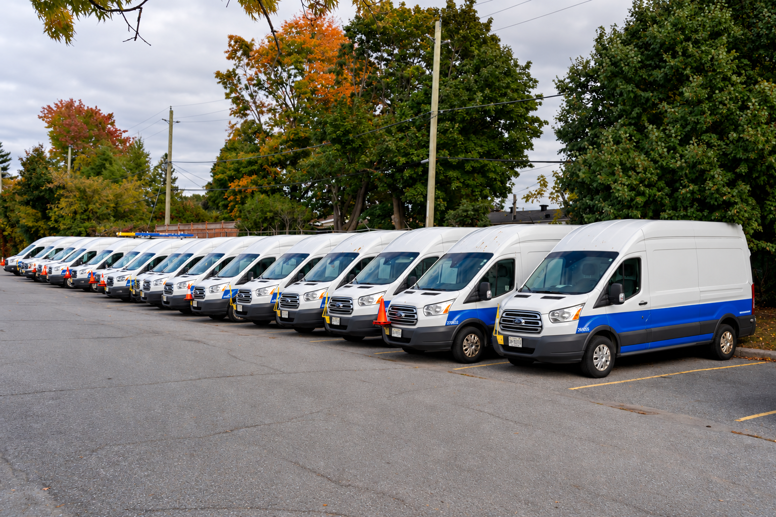 Row of white cargo vans parked together for fleet fueling